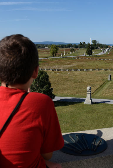 A young visitor looks out at the Gettysburg battlefiled from atop the Pennsylvania Memorial